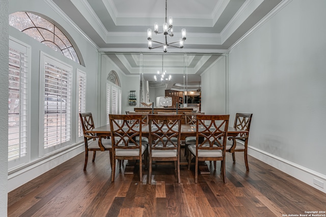 dining area featuring ornamental molding, dark wood-type flooring, and a raised ceiling