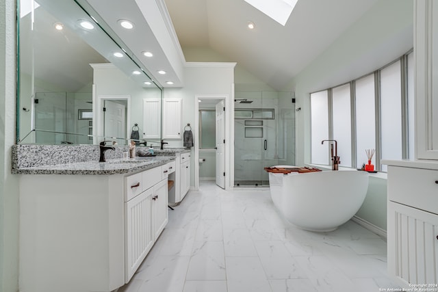 bathroom with vaulted ceiling with skylight, vanity, and separate shower and tub