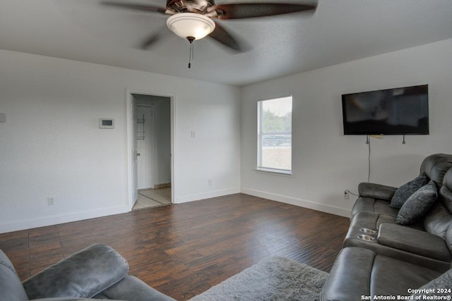 living room featuring ceiling fan and dark wood-type flooring