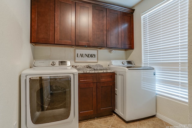 laundry area with cabinets, washing machine and dryer, and light tile patterned flooring