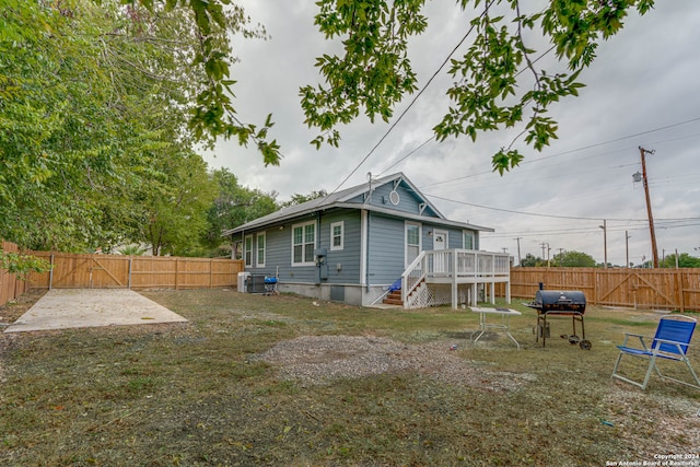 back of house featuring central AC unit and a deck