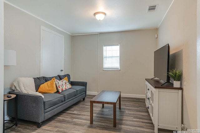 living room featuring ornamental molding and dark hardwood / wood-style flooring