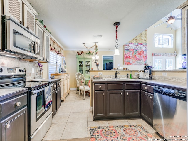 kitchen featuring ceiling fan with notable chandelier, sink, ornamental molding, pendant lighting, and appliances with stainless steel finishes