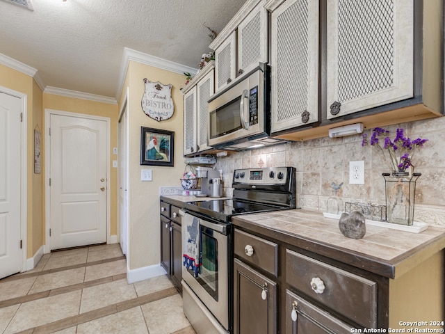 kitchen with backsplash, a textured ceiling, light tile patterned floors, and stainless steel appliances