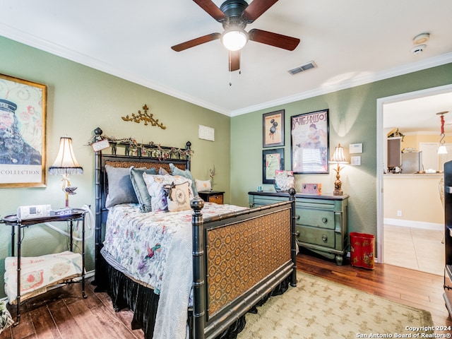 bedroom with hardwood / wood-style floors, ceiling fan, and crown molding