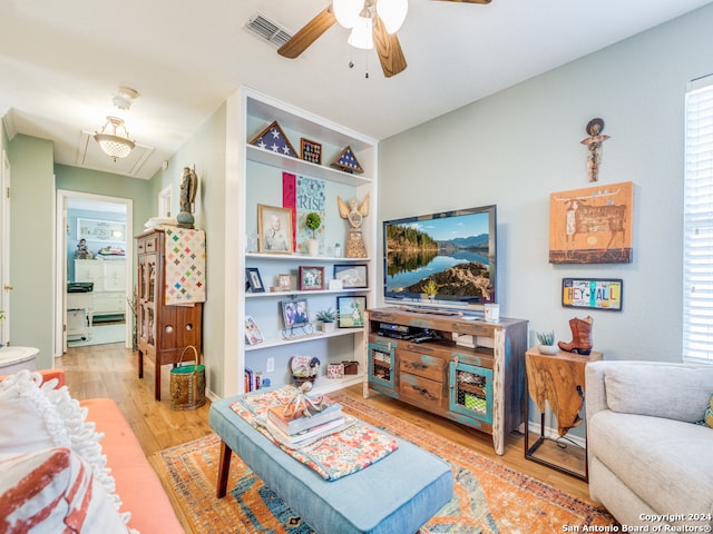 living room with light wood-type flooring and ceiling fan