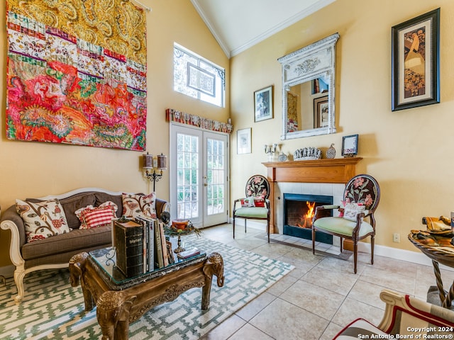 living area featuring light tile patterned flooring, a tiled fireplace, ornamental molding, french doors, and vaulted ceiling