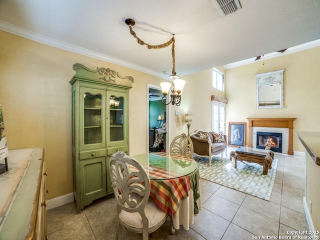 16 Pembroke Ln, San Antonio, TX 78240 - dining area with a tile fireplace, crown molding, light tile patterned flooring, a chandelier, and baseboards