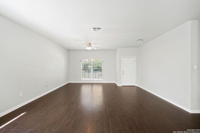 unfurnished room with dark hardwood / wood-style flooring and ceiling fan