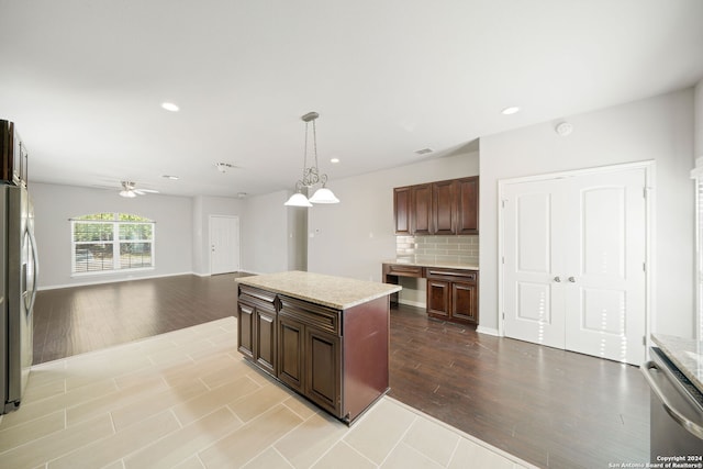 kitchen featuring light hardwood / wood-style floors, hanging light fixtures, tasteful backsplash, and a kitchen island