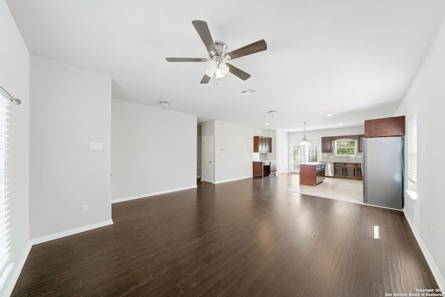 unfurnished living room featuring ceiling fan and dark hardwood / wood-style floors