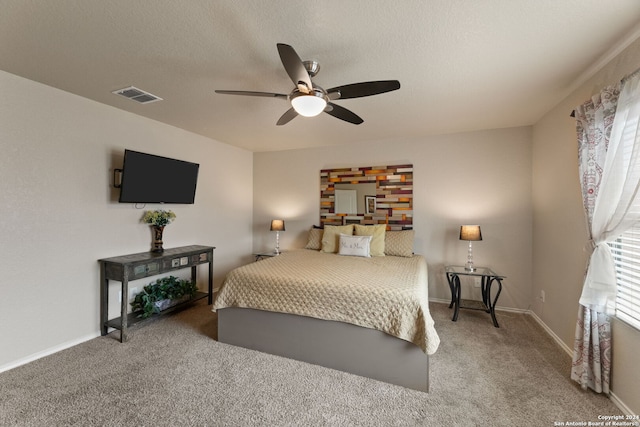 carpeted bedroom with a textured ceiling and ceiling fan