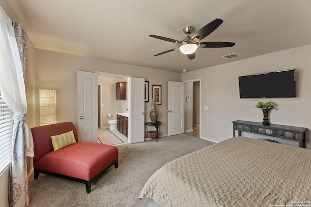 carpeted bedroom with a textured ceiling, ceiling fan, and connected bathroom