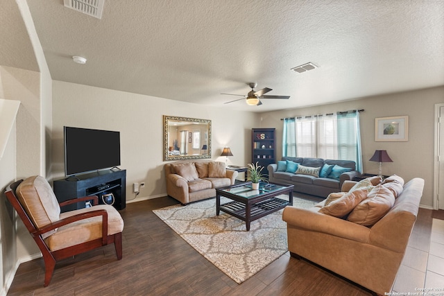 living room with ceiling fan, a textured ceiling, and dark hardwood / wood-style floors