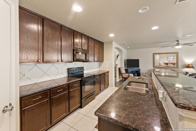 3922 Verde Bosque, San Antonio, TX 78223 - kitchen with black appliances, a sink, arched walkways, open floor plan, and tasteful backsplash