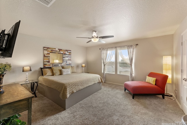 carpeted bedroom with ceiling fan and a textured ceiling