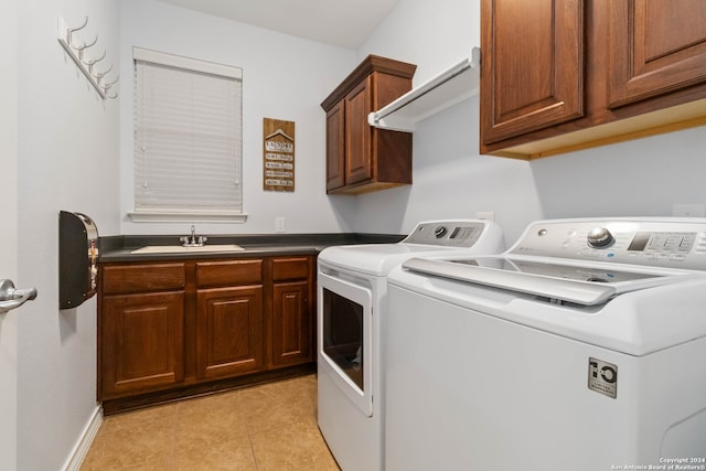 washroom with cabinets, light tile patterned floors, independent washer and dryer, and sink