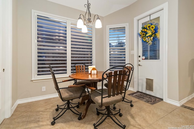 dining room with vaulted ceiling, light tile patterned floors, and an inviting chandelier