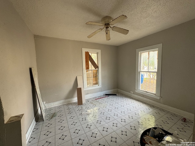 unfurnished room featuring ceiling fan and a textured ceiling