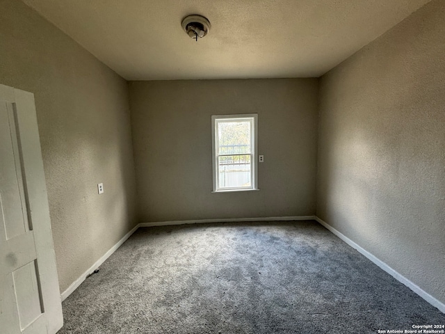 carpeted spare room with a textured ceiling