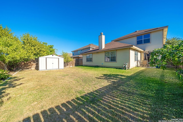 rear view of house featuring a lawn and a shed