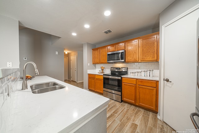 kitchen featuring backsplash, sink, and appliances with stainless steel finishes