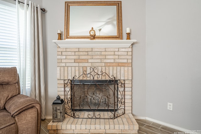 interior details featuring wood-type flooring and a brick fireplace