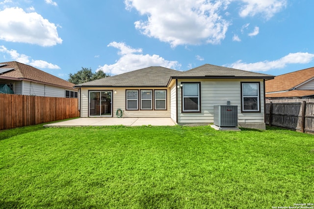 back of property with central AC, a patio area, and roof with shingles