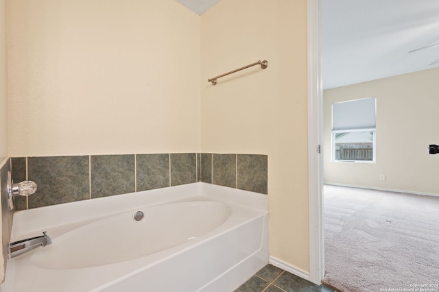 bathroom featuring a bath, baseboards, and tile patterned floors