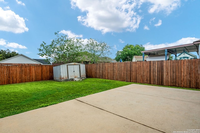 view of yard featuring a storage unit and a patio area