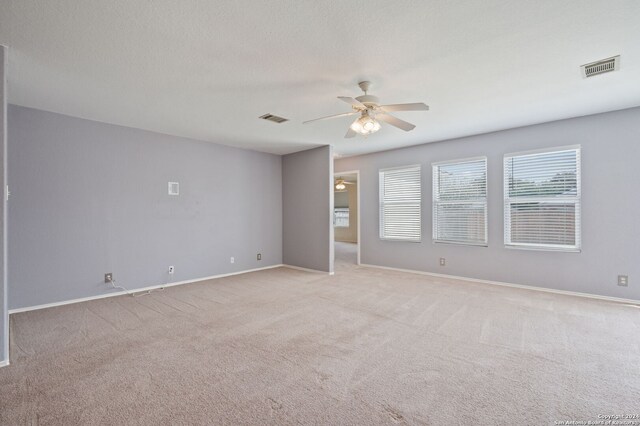 unfurnished room featuring a ceiling fan, light carpet, and baseboards