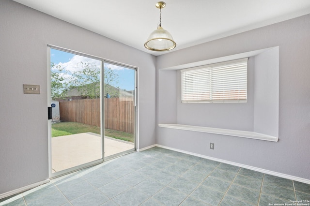 unfurnished dining area with baseboards and tile patterned flooring