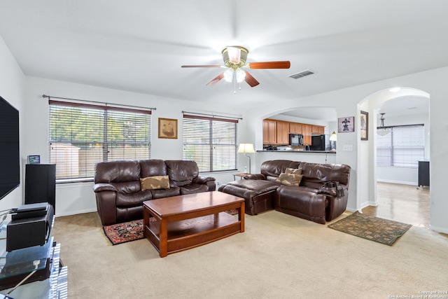 carpeted living room with ceiling fan