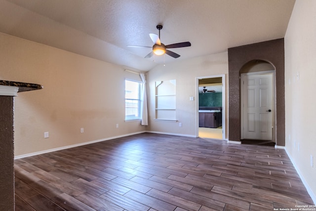 unfurnished living room featuring ceiling fan, dark hardwood / wood-style flooring, and a textured ceiling