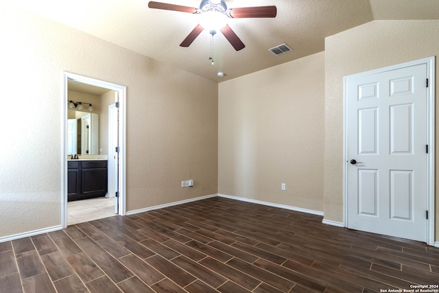 unfurnished bedroom featuring dark hardwood / wood-style floors, ensuite bath, and lofted ceiling