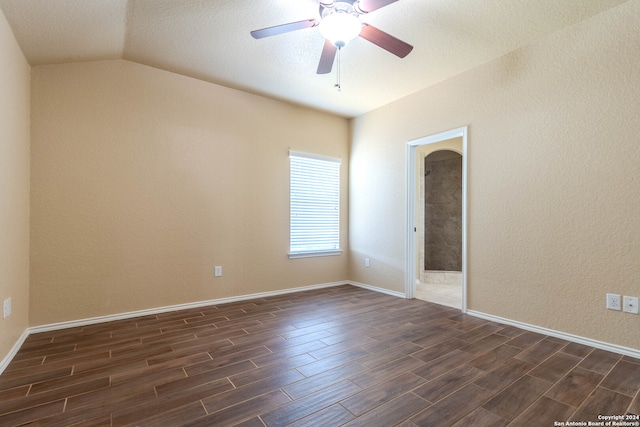 empty room with vaulted ceiling, ceiling fan, and dark hardwood / wood-style floors