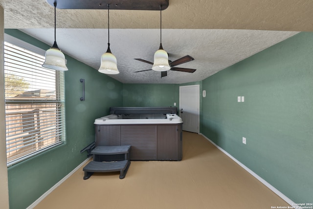 kitchen featuring a wealth of natural light, ceiling fan, concrete flooring, and a textured ceiling