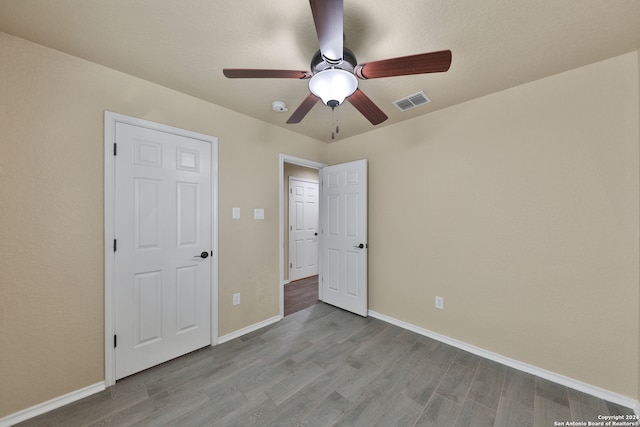 unfurnished bedroom with ceiling fan and light wood-type flooring