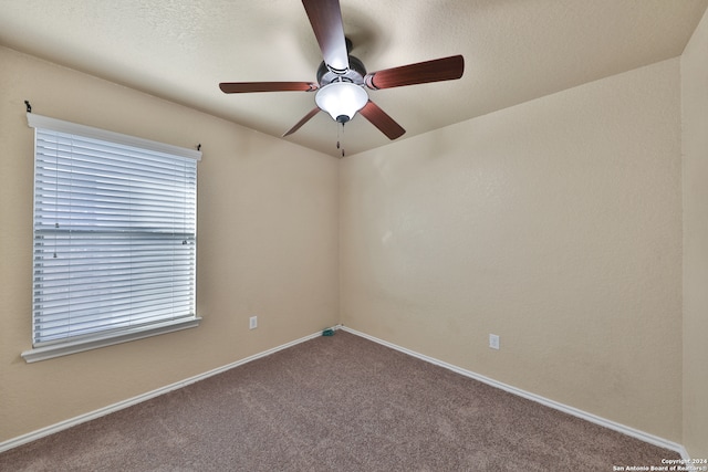 carpeted spare room featuring ceiling fan