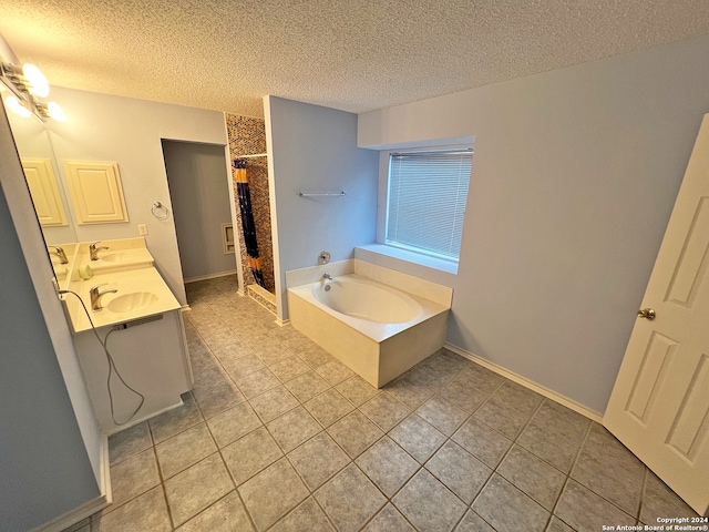 bathroom featuring vanity, a textured ceiling, tile patterned floors, and a tub