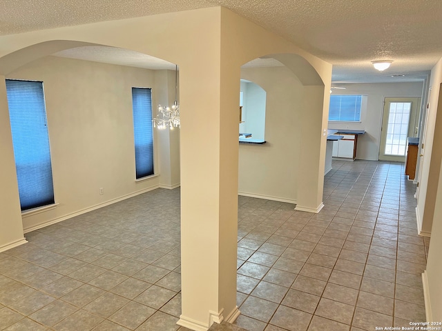 tiled spare room featuring a textured ceiling