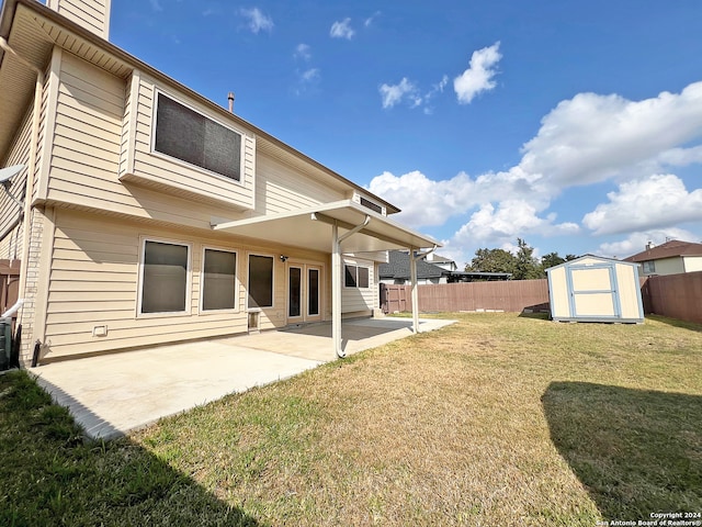 back of property with a patio area, a lawn, and a shed