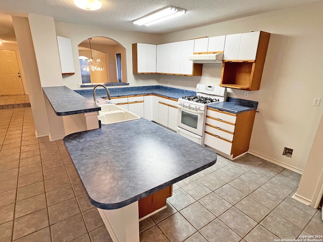 kitchen featuring white cabinetry, kitchen peninsula, white range with gas stovetop, and sink