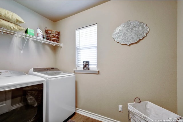 clothes washing area with wood-type flooring and washer and dryer