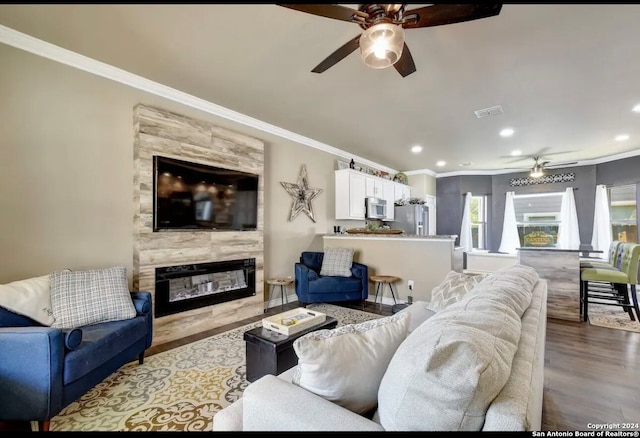 living room with light hardwood / wood-style floors, ceiling fan, and crown molding