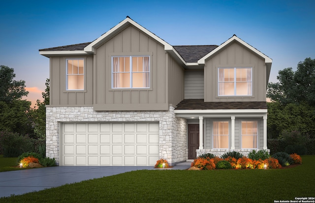 view of front of home with a garage and a lawn