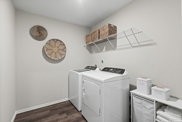 clothes washing area with washing machine and clothes dryer and dark hardwood / wood-style floors