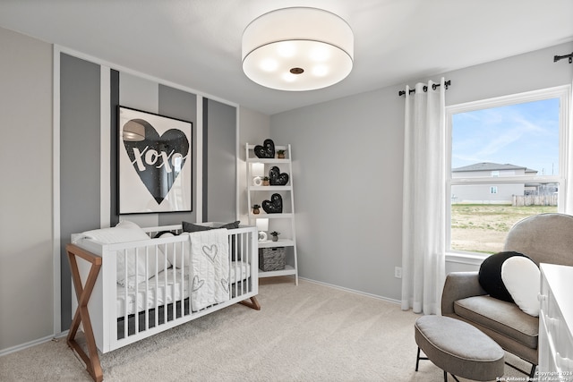 bedroom with a nursery area and carpet floors