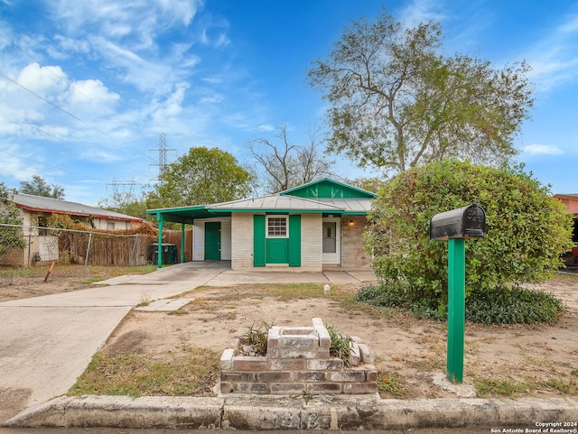 1818 Adamston Dr, San Antonio, TX 78220 - view of front of home with concrete driveway, fence, a carport, metal roof, and brick siding