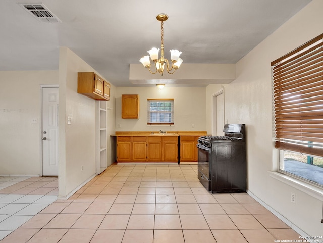 kitchen with gas stove, an inviting chandelier, sink, and light tile patterned floors